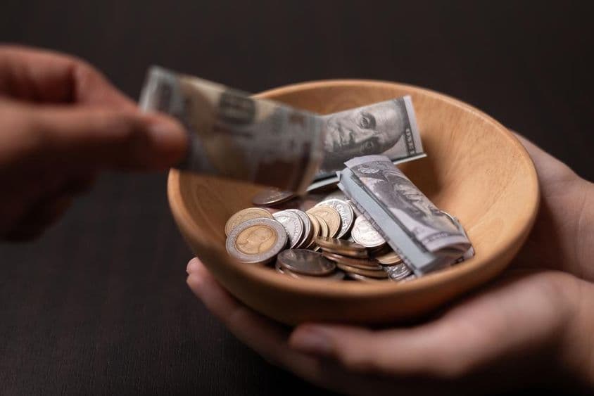 Donación siendo recolectada en un recipiente de madera.