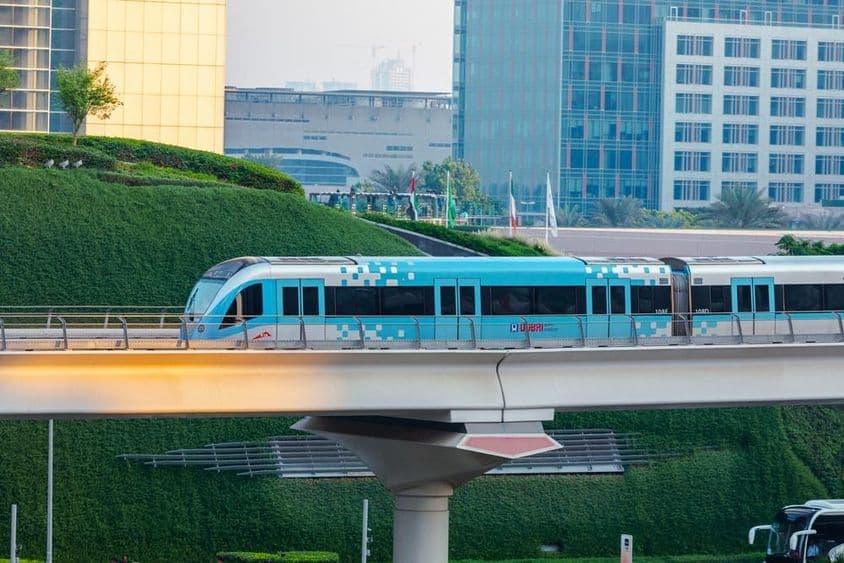 Tren de metro sin conductor moviéndose en la ciudad de Dubái en un día soleado.