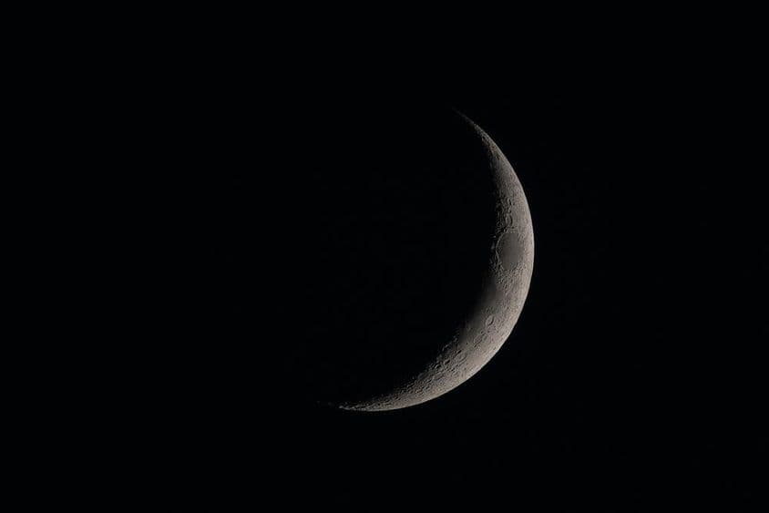 Luna nueva detallada en el cielo oscuro.