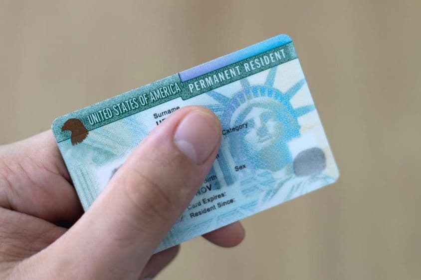 Un residente permanente en EE.UU. sostiene una tarjeta verde en la mano.