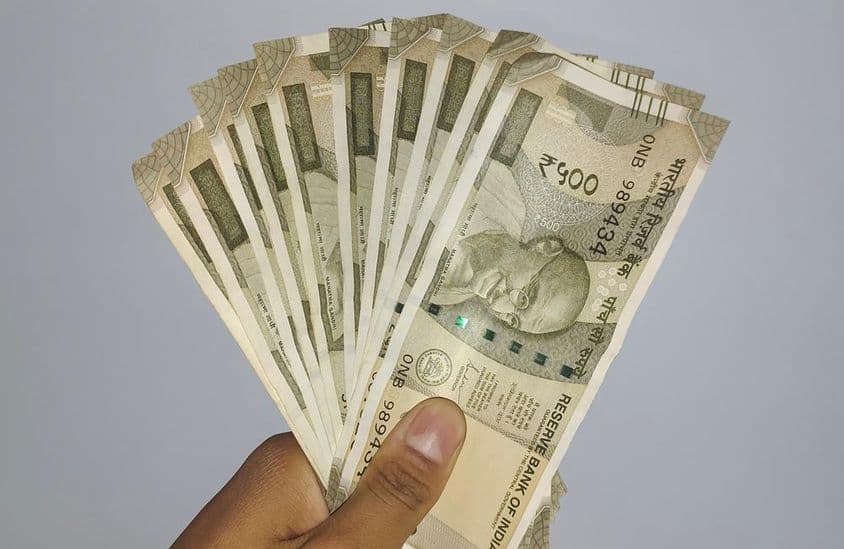 Sosteniendo billetes de 500 rupias indias.