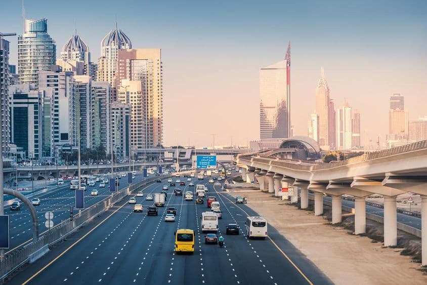 Autopista con líneas de metro y rascacielos en el área de Dubai Marina