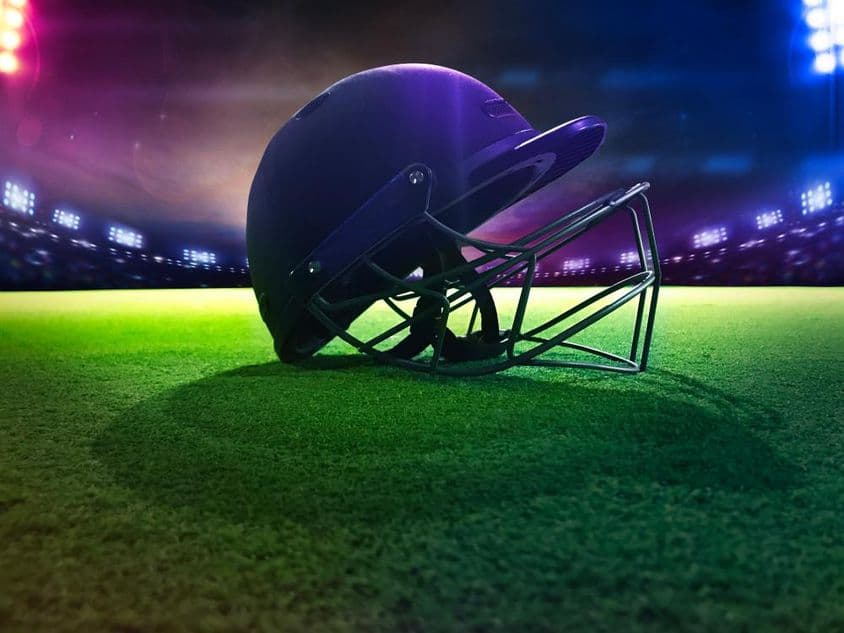 Casco de cricket desde abajo sobre césped verde.