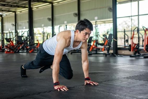 Hombre en gimnasio levantando la pierna y moviéndose