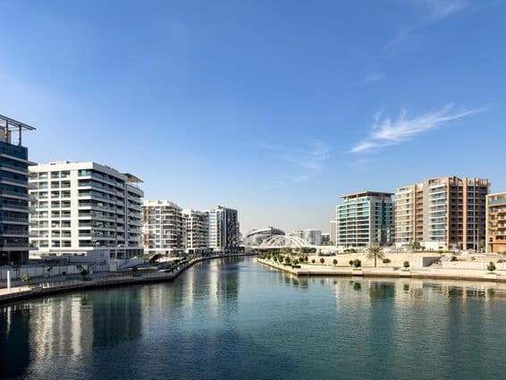Edificios residenciales y canal en el barrio Al Raha Beach y comunidad en Abu Dhabi.
