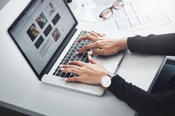 Mujer trabajando remotamente desde casa usando una laptop.