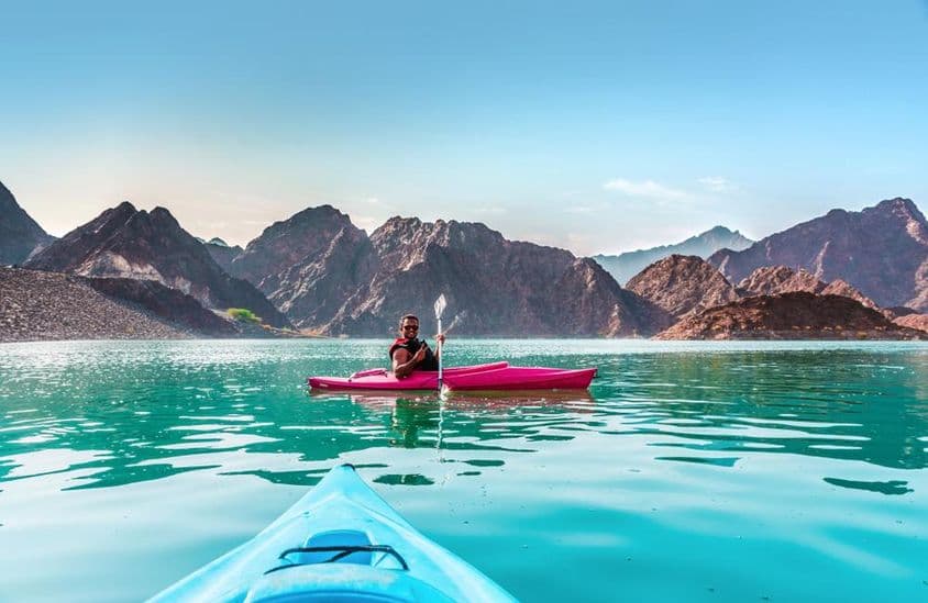 Joven en kayak en la presa de Hatta, el mejor lugar para actividades de aventura acuática, en Dubái.