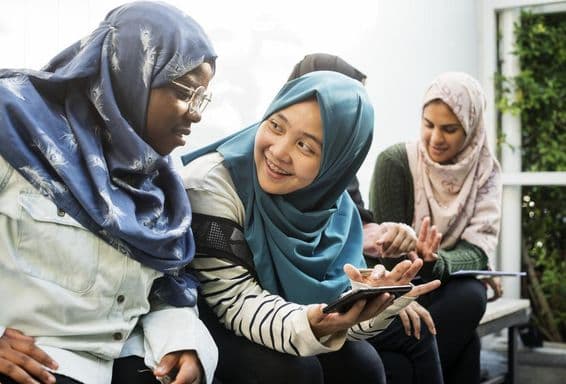 Grupo de estudiantes usando teléfonos móviles.