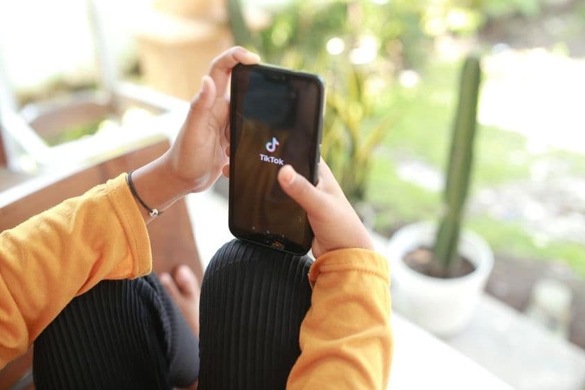 Un niño viendo contenido de medios TikTok en un celular.