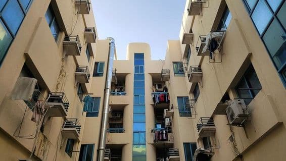 Edificio de vivienda asequible en Dubái con balcón, aire acondicionado y lavandería.