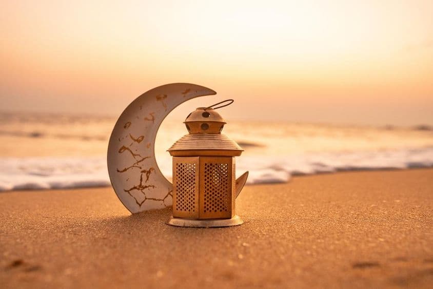 Tradicional media luna iluminada con velas en la playa.