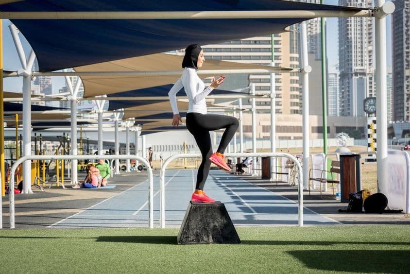 Mujer árabe haciendo ejercicio, usando un hijab.
