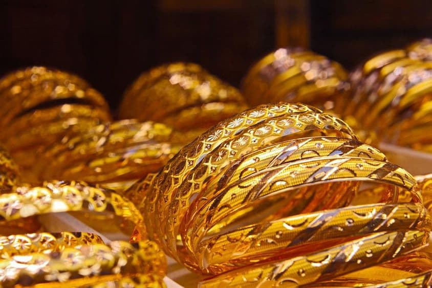 Pulseras de oro amontonadas en una tienda de joyería.