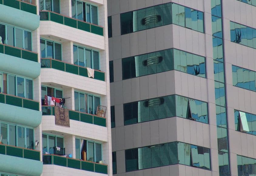 Un moderno rascacielos en Abu Dabi con algunos balcones con alfombras.