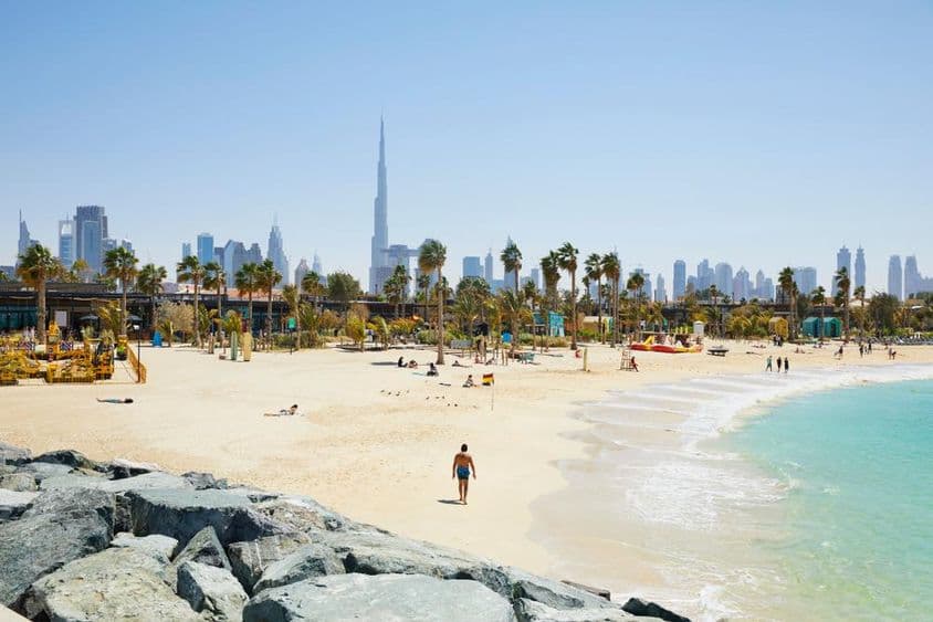 Playa con el skyline de Dubái al fondo, Emiratos Árabes Unidos.