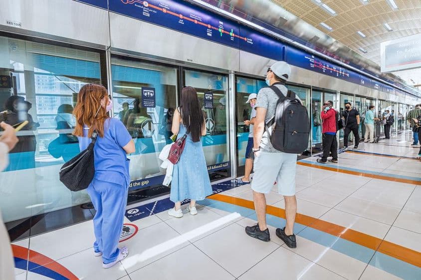 Dubái, pasajeros abordando el tren del metro que arriba.