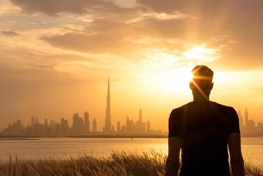 Silueta de un hombre observando el hermoso horizonte de la ciudad al atardecer.