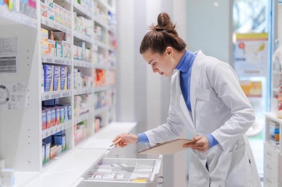 Farmacéutico joven revisando el stock de medicinas en una farmacia.