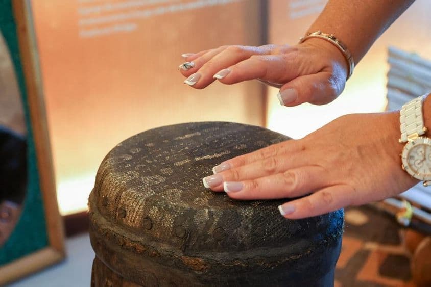 Dubái, Emiratos Árabes Unidos, Mujer africana tocando un tambor de percusión.