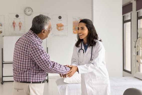 Joven doctora sonriente examinando a un paciente.