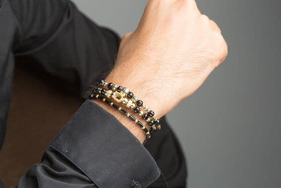Pulsera de oro masculina en muñeca.