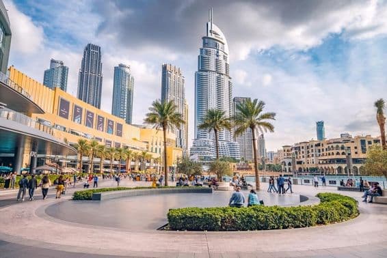 Multitudes de turistas caminando por la plaza y el paseo cerca de la entrada del Dubai Mall.
