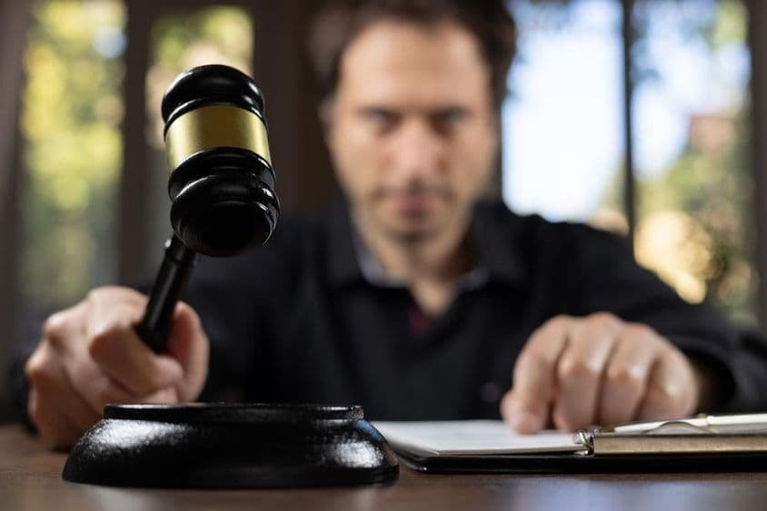 Un juez sosteniendo un mazo señalando el fin de un juicio.