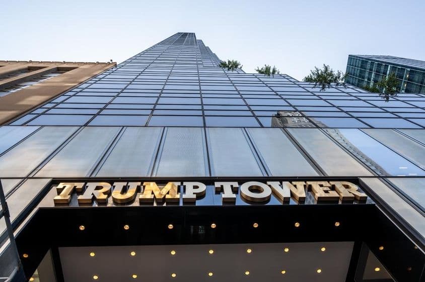Foto icónica de la entrada de Trump Tower destacando el cartel de metal dorado.