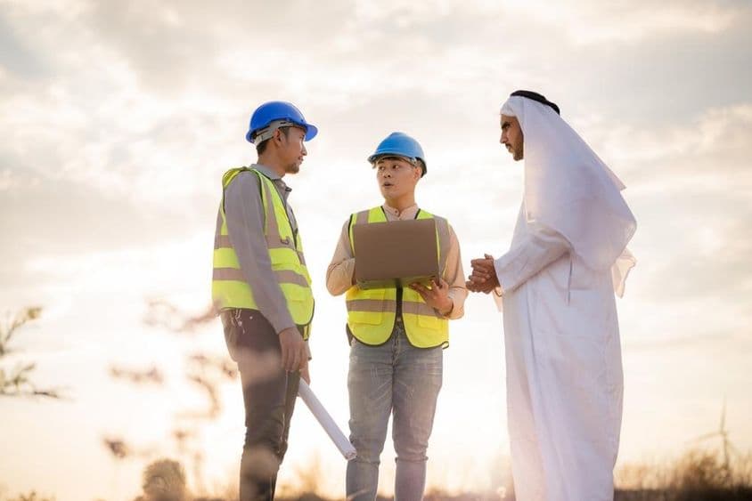 Ingeniero asiático y empresario árabe discutiendo en una construcción.