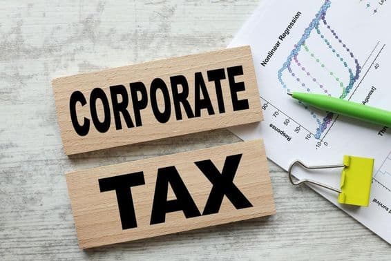 Impuesto corporativo en dos cubos de madera.