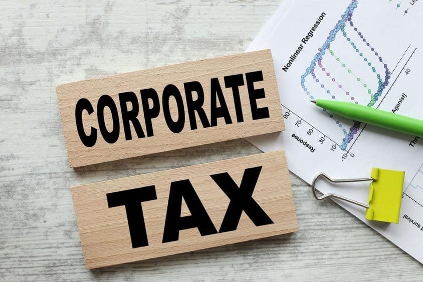 Impuesto corporativo en dos cubos de madera.