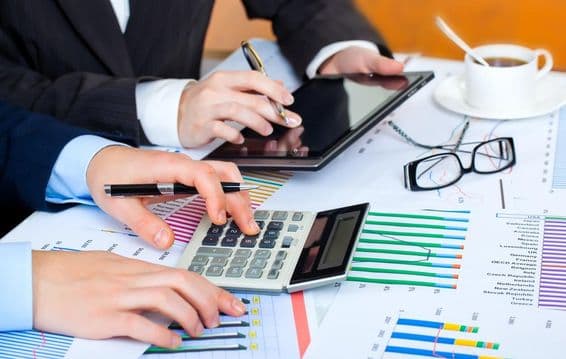 Gráficos, calculadora, tableta, manos diligentes estudiando los datos.