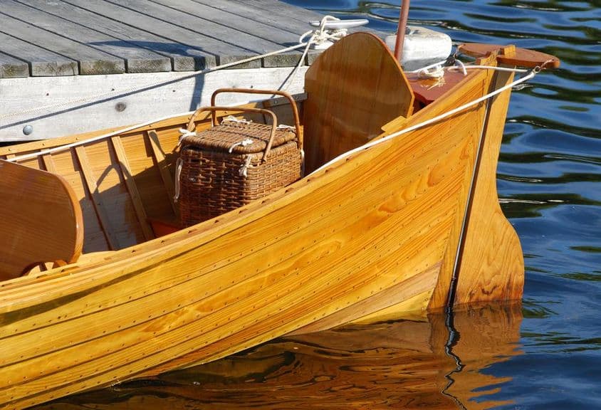 Barco antiguo con canasta de picnic en popa.