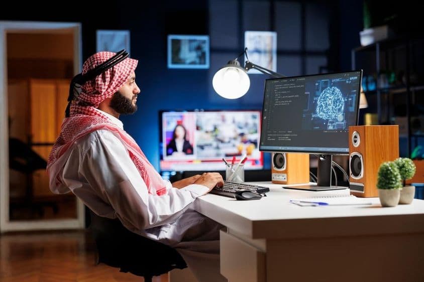 Un hombre profesional en atuendo árabe trabajando en una interfaz de usuario futurista.
