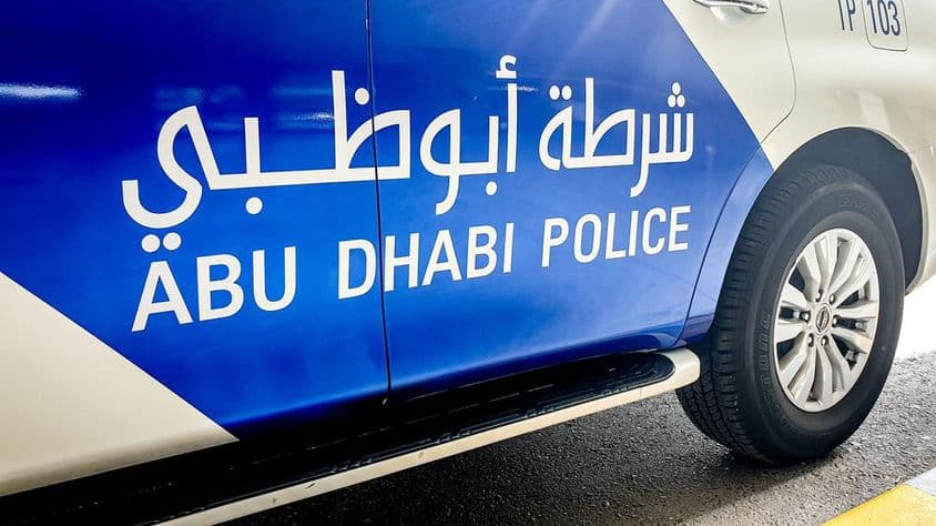 Coche patrulla en Abu Dhabi con letras en inglés y árabe.