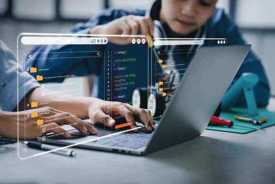 Estudiantes adolescentes trabajando en tareas relacionadas con brazos robóticos y coches robot.