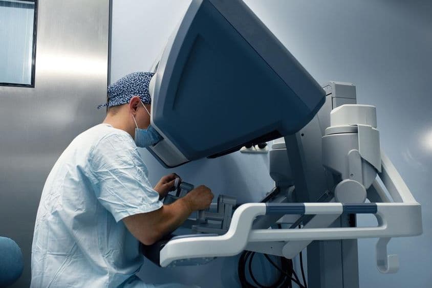 Un robot médico es operado de forma remota por un doctor a través de un monitor.