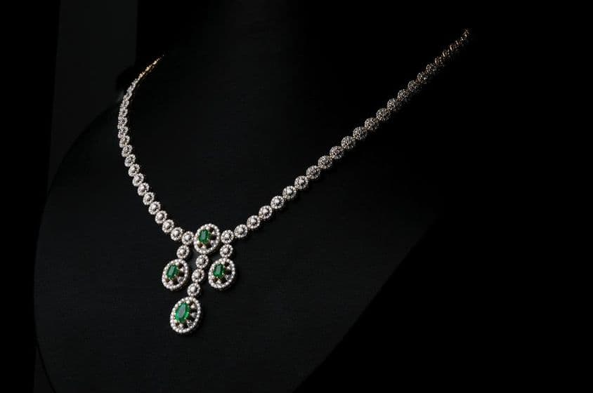 Collar de diamantes con gema verde esmeralda.