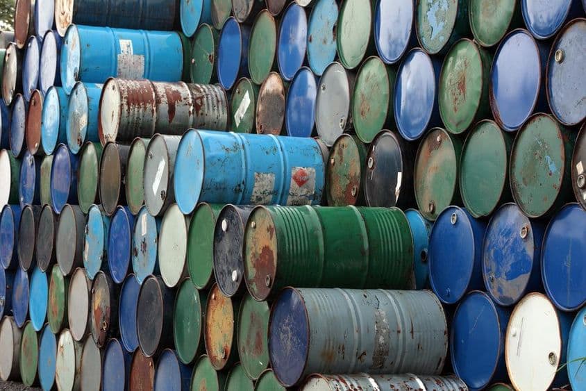 Barriles de petróleo oxidados apilados uno sobre otro.