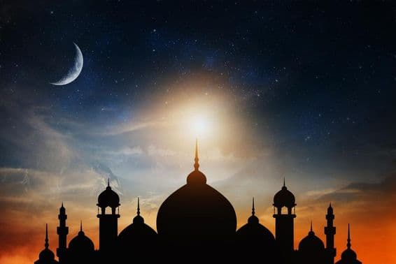 Cúpulas de mezquita contra un cielo crepuscular azul profundo con una luna creciente al fondo.