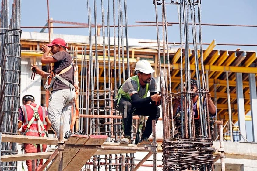Dubái, Emiratos Árabes Unidos, hombres trabajando en un sitio de construcción.
