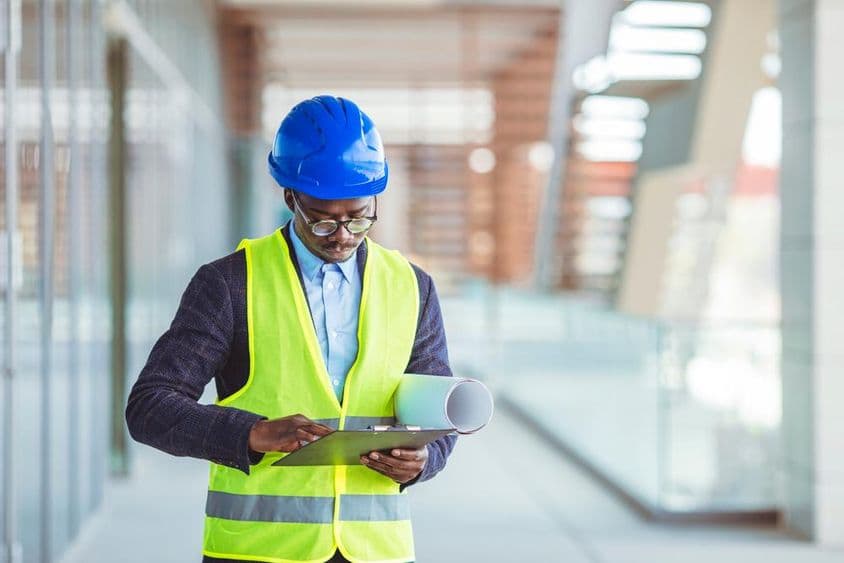 Joven ingeniero civil analizando estadísticas en papel.