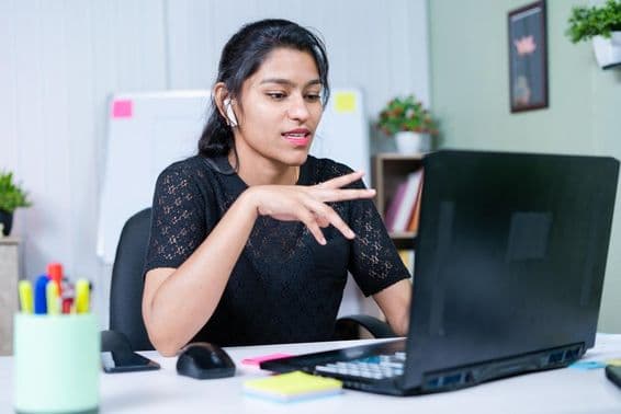 Joven empresaria india convenciendo a un cliente sobre un proyecto mediante una videollamada.