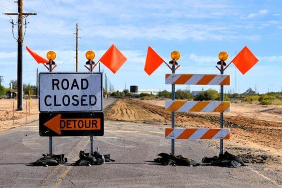 señales de desvío por cierre de carretera y banderas naranjas de advertencia