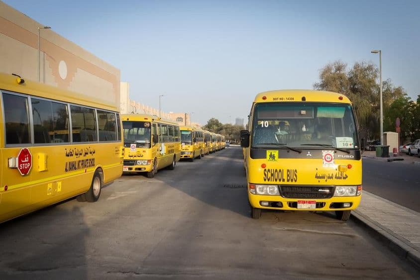 Autobuses escolares amarillos alineados y estacionados en Abu Dhabi.