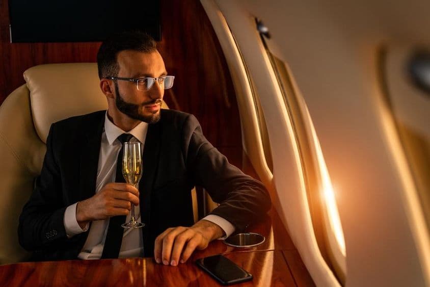 Empresario en un elegante traje, volando en un jet privado exclusivo.