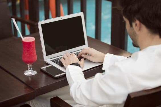 Joven empresario árabe trabajando con un portátil en un café.