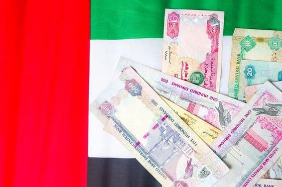 Billetes de dirham de EAU sobre la bandera nacional.