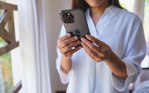 Una mujer usando un iPhone 15 Pro Max en casa.