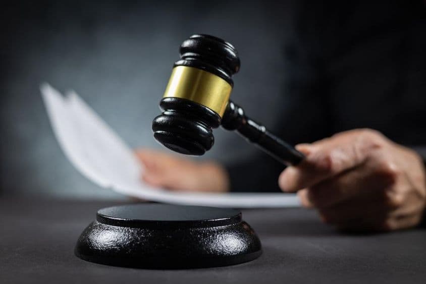 Juez anuncia veredicto con documento en el tribunal.